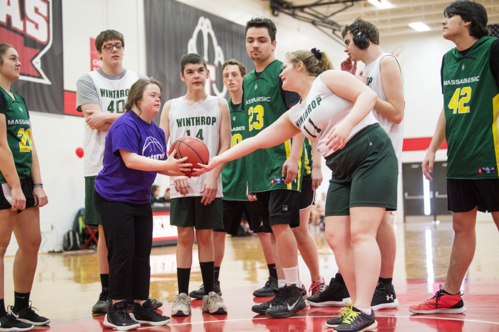 Winthrop High School's Samantha Neumann (11) hands the ball off to an opponent from Waterville for another scoring attempt at the Unified basketball tournament Saturday at Thomas College in Waterville.