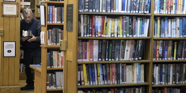 Hubbard Free Library volunteer Byron Hill works in the stacks Thursday in Hallowell.