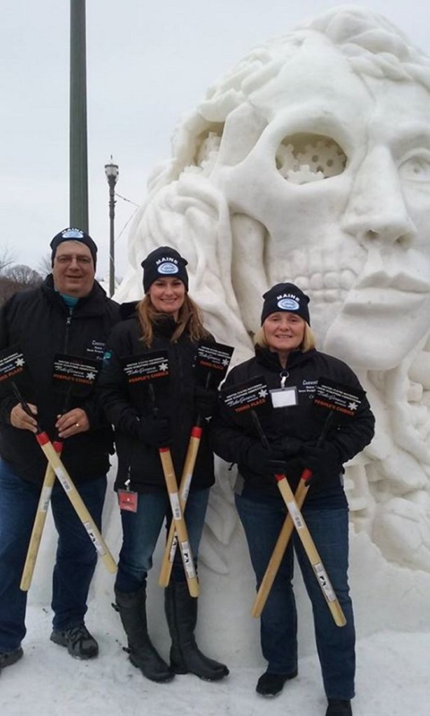 The team of Paul Warren, Amanda Bolduc and Cathy Thompson pose in front of their sculpture "Hello, Can You Tell Me the Way to the Heart?" The sculpture won third place and the People's Choice Award at a 2017 national competition.