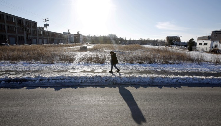 The city of Portland and the Federated Cos. blame each other for holding up progress on the Midtown development, planned on a site that's now covered with weeds.