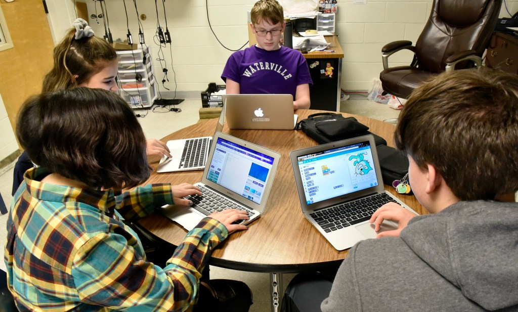 Waterville Junior High School students, clockwise from lower left, Alexa DeWitt, Leilani Gomez, Zachary London and Dylan Mitchell, work on assignments with computers Thursday. When they move up to Waterville Senior High School, they will have the opportunity to participate in a unique computer science pilot program funded by an $881,000 grant from the Harold Alfond Foundation.