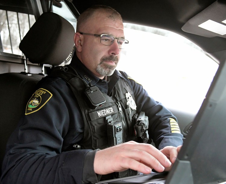 Gardiner police Officer Marcus Niedner types notes from a radio call in his cruiser Feb. 7 in Gardiner. Police can review calls that are dispatched to them on the computer.  