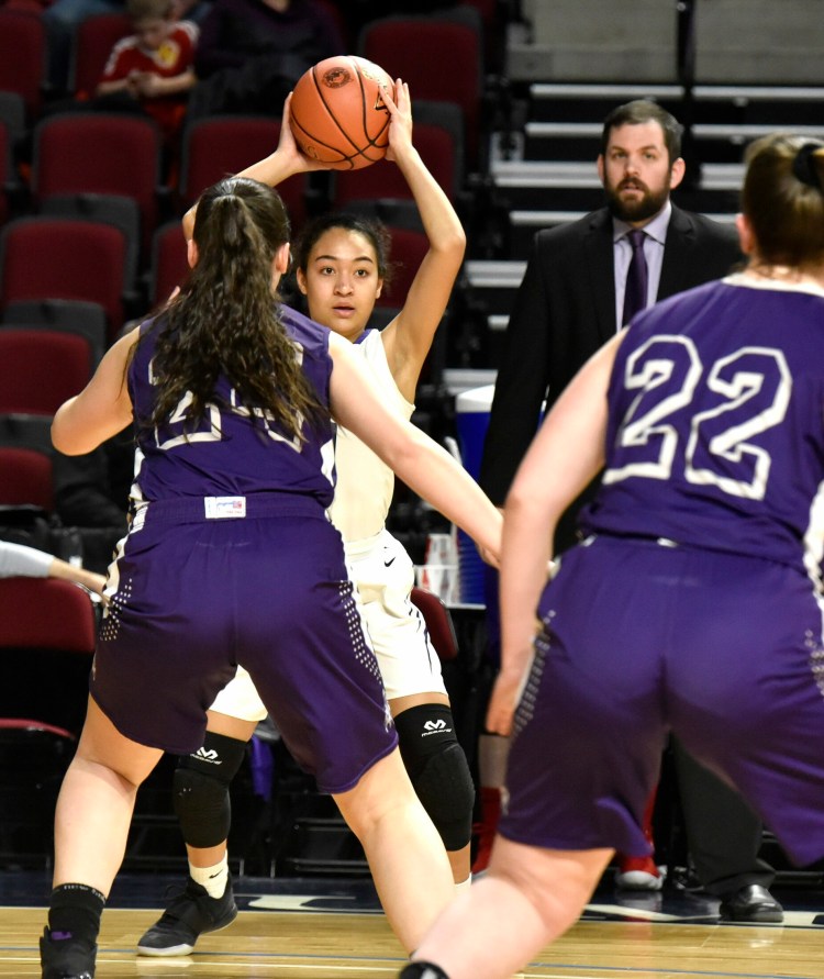 Waterville's Kali Thompson looks to pass as a pair of John Bapst players defend during a Class B North quarterfinal game Friday night in Bangor.