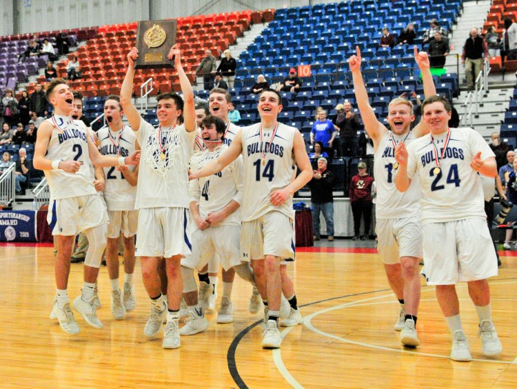 Lawrence's Kobe Nadeau holds high the championship trophy as the  team celebrates winning the Class A North championship Friday night at the Augusta Civic Center.