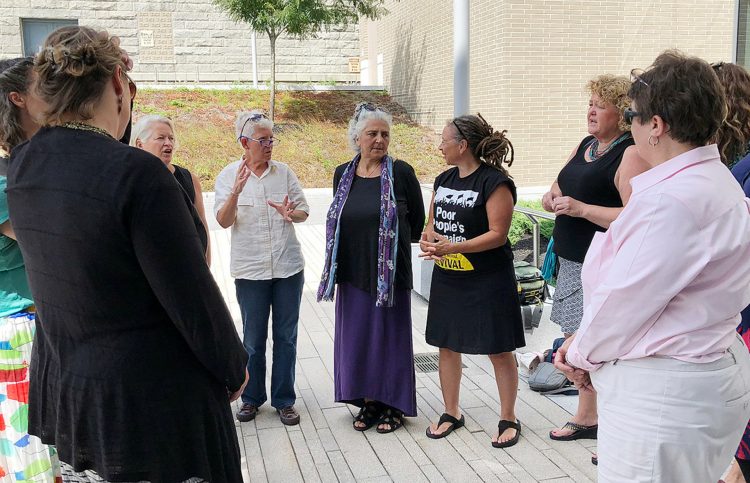 Defendants charged May 14, 2018, with criminal trespass at the Blaine House — the governor's mansion — confer with each other and with one of their attorneys Aug. 21, 2018 after a hearing at the Capital Judicial Center in Augusta.