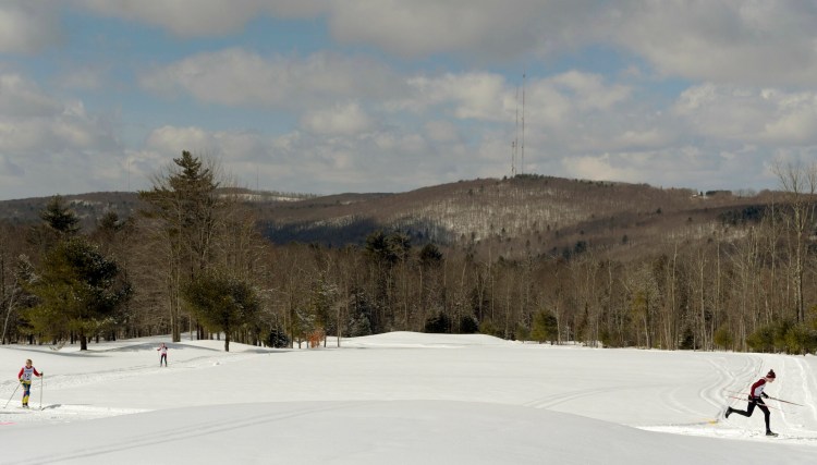 Skiers and runners cross the snow-covered greens Sunday during the triathlon held at the Meadows Golf Club in Litchfield. Competitors from several states and across Maine skied, shoed, ran and biked for several miles.