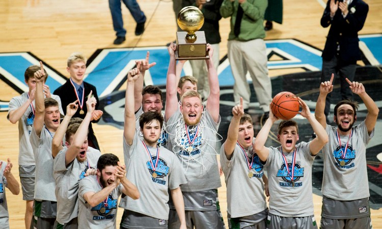 Winthrop senior Cam Wood, center, hoists the Gold Ball over his head to celebrate the team's Class C state title Saturday night in Bangor.