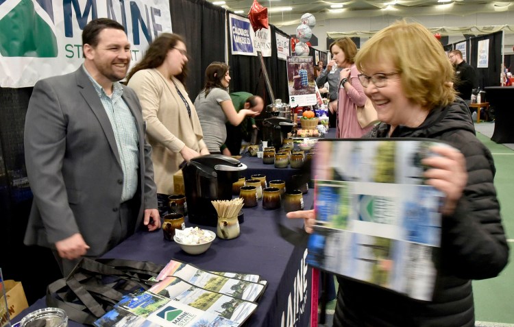 Bruce Harrington, of Maine State Credit Union and chairman of the Business to Business Showcase committee, gives away a reusable bag to a patron of the event, held Thursday at Colby College in Waterville.
