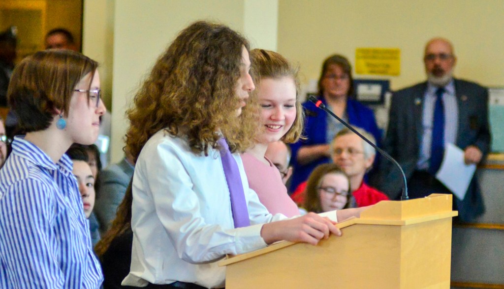 Maranacook Community High School student, Claire Holman, 14 of Mt. Vernon, and Marancook Community Middle School students Mary Hatt, 14 of Mt. Vernon and Malachi Vazquez-Carr, 14 of Fayette, testify in favor of LD 798, An Act To Protect Maine Children and Students from Preventable Diseases by Repealing Certain Exemptions from the Laws Governing Immunization Requirements, before the Education and Cultural Affairs committee on Wednesday in the Cross State Office Building in Augusta.