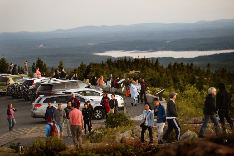  Hundreds flock to Cadillac Mountain in Acadia National Park on a late-July day to see the sunrise. The National Park Service has proposed raising entrance fees at Acadia and 16 other parks to generate revenue to reduce the backlog in maintenance and infrastructure projects at the sites. 