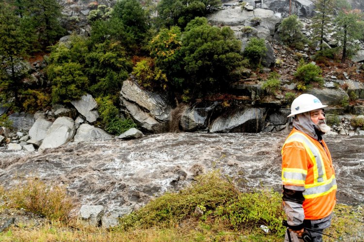 Caltrans maintenance supervisor Matt Martin surveys a landslide covering Highway 70 in the Dixie Fire zone on Sunday in Plumas County, Calif. 