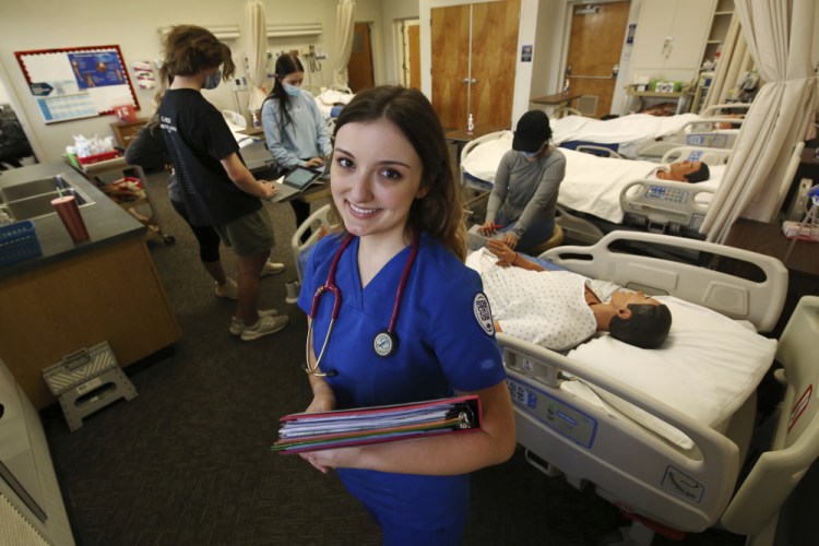 First year nursing student, Emma Champlin, poses for a photo in her clinical laboratory class at Fresno State on Wednesday in Fresno, Calif. Champlin said that like many of her classmates, she saw the pandemic as a chance to learn critical-care skills and to help at a time when those abilities are needed.