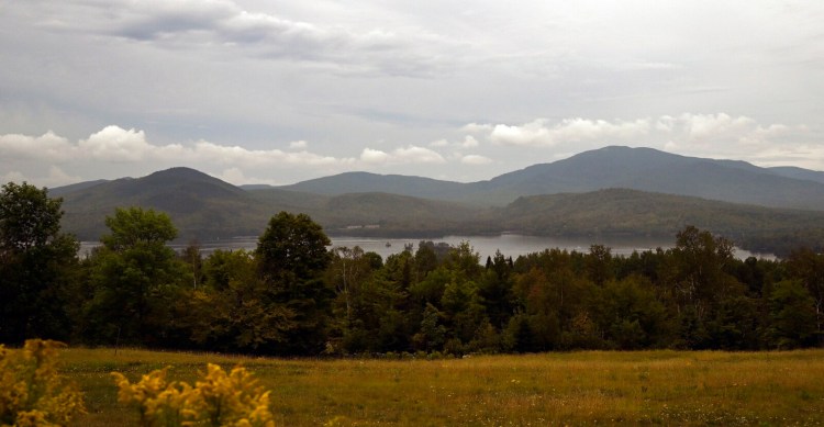 Looking across Moosehead Lake to the general area where the Moosehead Trail Alliance hopes to build a new 25-mile mountain bike trail Thursday, August 19, 2021. The small peak to the far left is Little Moose Mountain and the larger peak on the right is Big Moose Mountain. (Staff Photo by Shawn Patrick Ouellette/Staff Photographer)