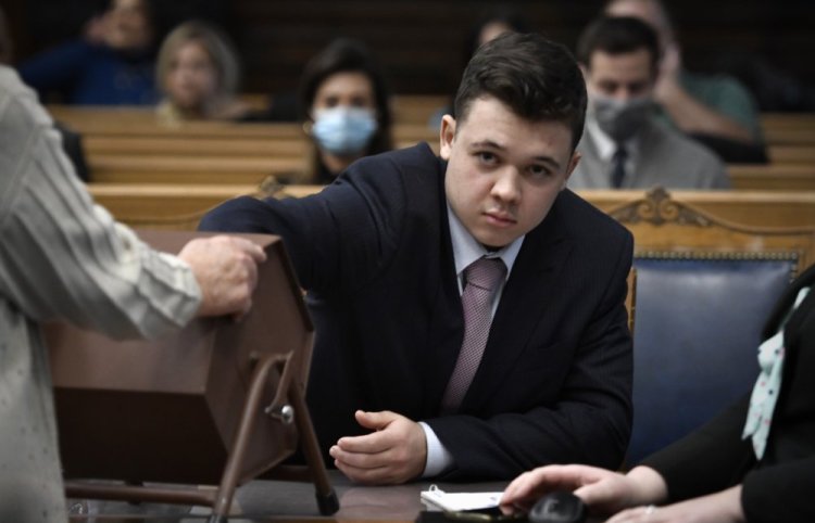 In an unusual move, Kyle Rittenhouse is allowed to pull numbers of jurors out of a tumbler during his trial at the Kenosha County Courthouse in Kenosha, Wis., on Tuesday. The jurors selected through this process will not participate in deliberations. 