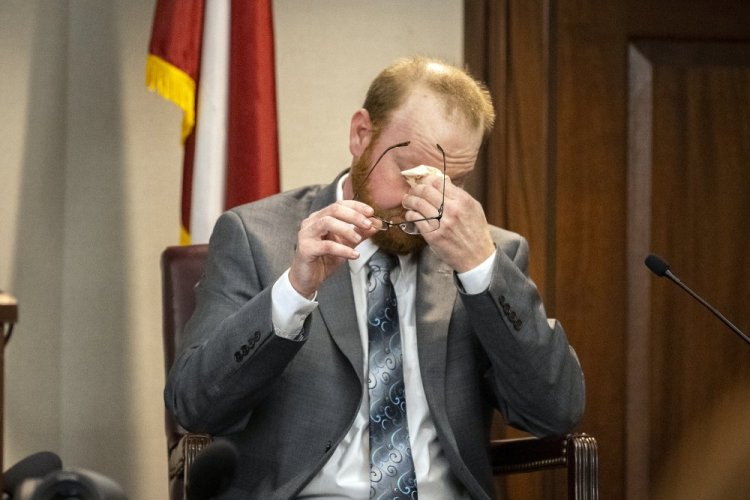 Travis McMichael reacts to questions during his testimony in his trial on charges of killing Ahmaud Arbery in the Glynn County Courthouse on Wednesday in Brunswick, Ga. He and his father, Greg McMichael, and neighbor William "Roddie" Bryan are all charged in the case. 