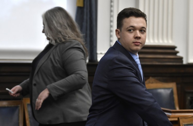Kyle Rittenhouse, right, watches as jurors leave  the room for a break during his trail at the Kenosha County Courthouse in Kenosha, Wis., on Monday.  Rittenhouse is accused of killing two people and wounding a third during a protest over police brutality in Kenosha, last year. 
