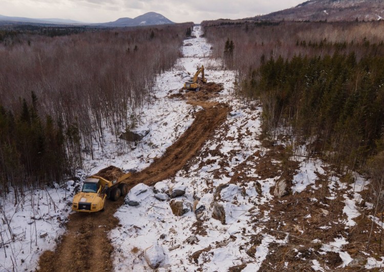 A truck carries ground-up treetops along the New England Clean Energy Connect corridor in Johnson Mountain Township in November. Construction work on the project has been halted as the result of a voter-approved ban that's being challenged in Maine's highest court.