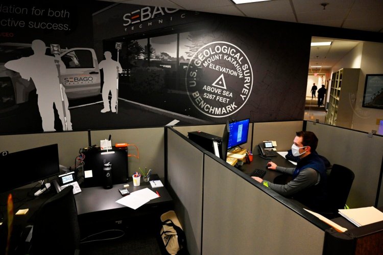 Dana Burbank, a 3D modeler/CAD support technician with Sebago Technics, works in the new server-geomatics team area at the company's office in South Portland on Friday. Sebago Technics has made pandemic-era changes such as providing more sanitation options for workers and making sure people are at desks with walls separating them from other workers.