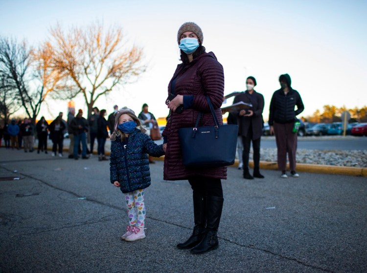 Meagan L’Heureux of Biddeford waits with her daughter, Jasmine Dow, 5, in a line for the Northern Light Home Care & Hospice vaccination clinic at the Maine Mall on Tuesday. Meagan was getting her booster shot, while her daughter was getting her first vaccination shot. 