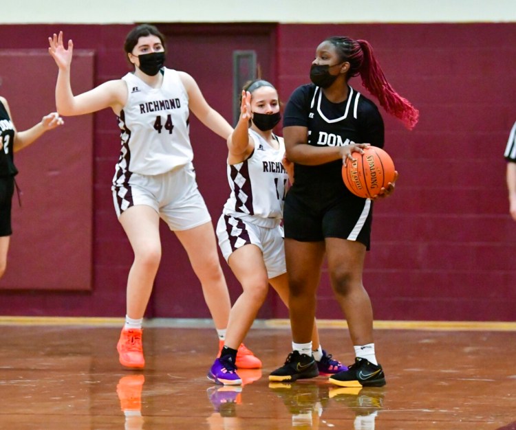 Richmond's Izzy Stewart (44) and Lila Viselli play defense on St. Dominic's Bennie Yombe during a girls basketball game Thursday in Richmond.