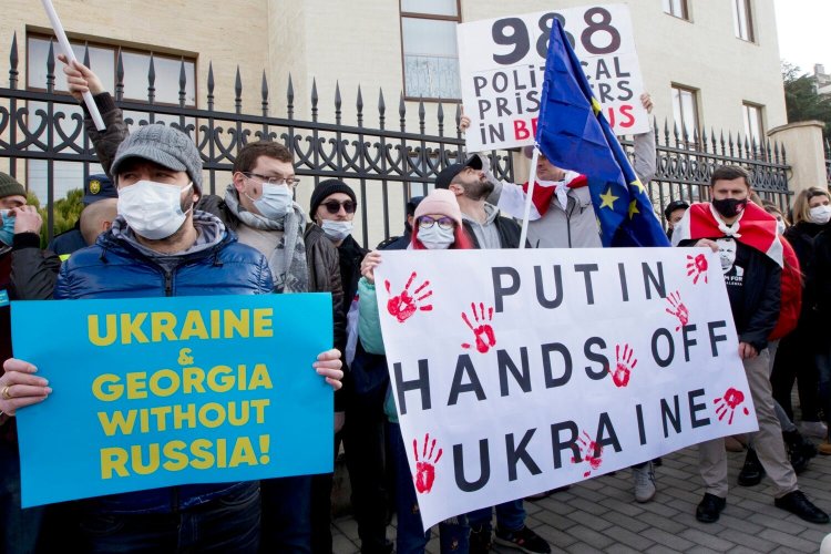 Georgian activists hold posters as they gather in support of Ukraine in front of the Ukrainian Embassy in Tbilisi, Georgia, on Sunday. The British government on Saturday accused Russia of seeking to replace Ukraine's government with a pro-Moscow administration, and said former Ukrainian lawmaker Yevheniy Murayev is being considered as a potential candidate. 