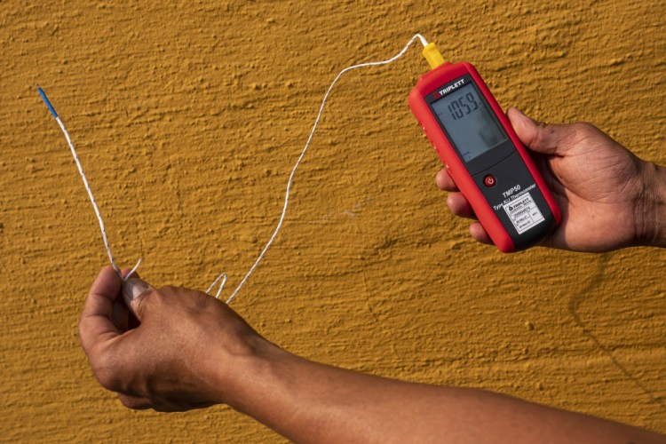 Vivek Shandas, a professor of climate adaptation at Portland State University, takes a temperature reading of almost 106 degrees in downtown Portland, Ore., on Aug. 12, 2021. 