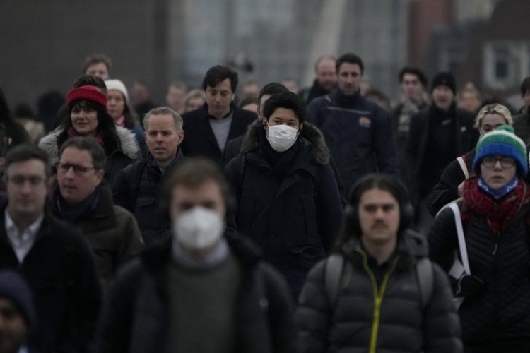 Workers walk over London Bridge during the morning rush hour Monday. The British government asked people to return to working in offices starting Monday as it eases coronavirus restrictions.