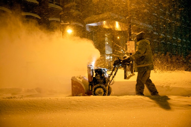 Crews clear the heavy snowfall from the Hathaway Creative Center parking lot in Waterville on Saturday. 