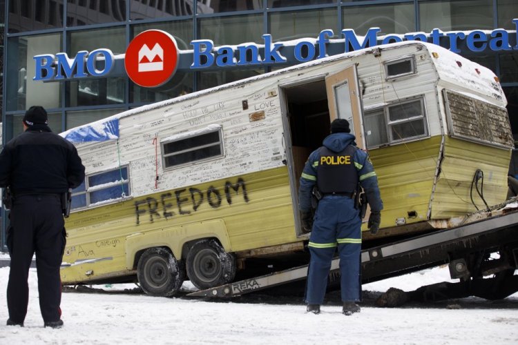 A camper is towed away Sunday by authorities clearing a trucker protest in Ottawa that was aimed at COVID-19 measures. 