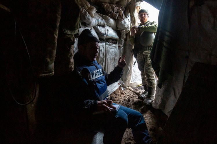 Mike Eckel conducts interviews in the trenches alongside a Ukrainian Marine infantry unit, near Verkhnotoreske, Ukraine, on Feb. 2