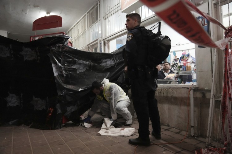 A member of Israeli Zaka Rescue and Recovery team cleans  the site where a gunman opened fire in Bnei Brak on Tuesday. The Israeli military announced it would be deploying additional troops to the West Bank.
