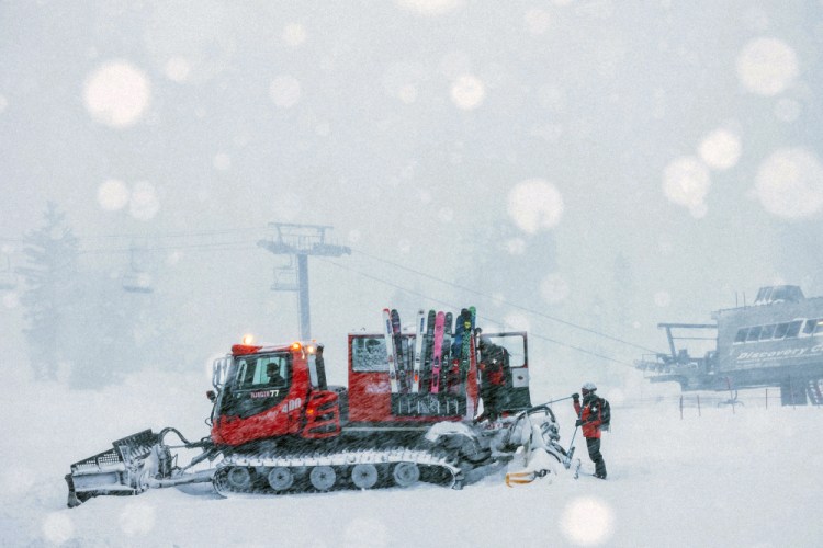 Crew members get ready to board on a snow plow in Mammoth Mountain in Mammoth Lakes, Calif., on Friday.

