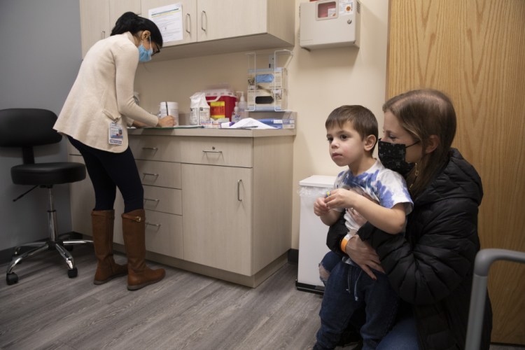 Ilana Diener holds her son, Hudson, 3, during an appointment for a Moderna COVID-19 vaccine trial in Commack, N.Y. on Nov. 30.