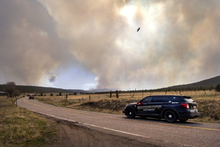 San Miguel County sheriff's officers patrol N.M. 94 near Penasco Blanco, N.M., as the Calf Fire burns on Friday. 
