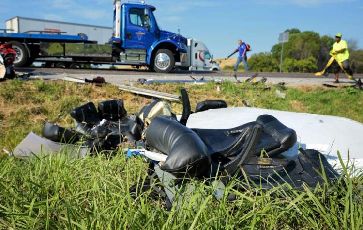 Workers clear debris from westbound Interstate 70 on Wednesday after a Greyhound passenger bus collided with a tractor-trailer near Highland, Ill. 