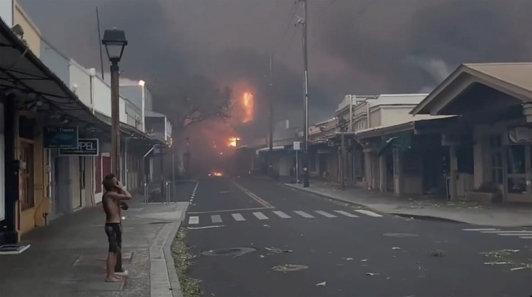 People watch as smoke and flames fill the air on Front Street in downtown Lahaina, Maui, last Tuesday. A week later, authorities are worried about returning to some parts of the island where toxic byproducts of the fire likely remain. Alan Dickar via AP