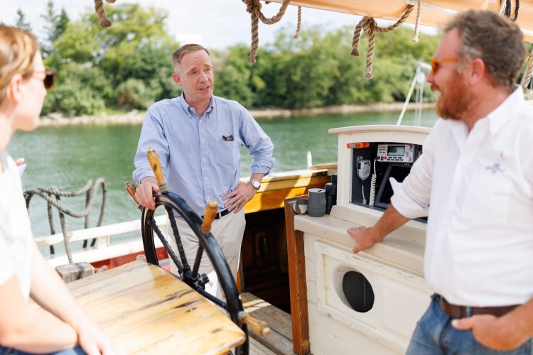 Marc Evan Jackson, center, on board the Grace Bailey in August with co-owners Suzannah Smith, left and Sam Sikkema. 