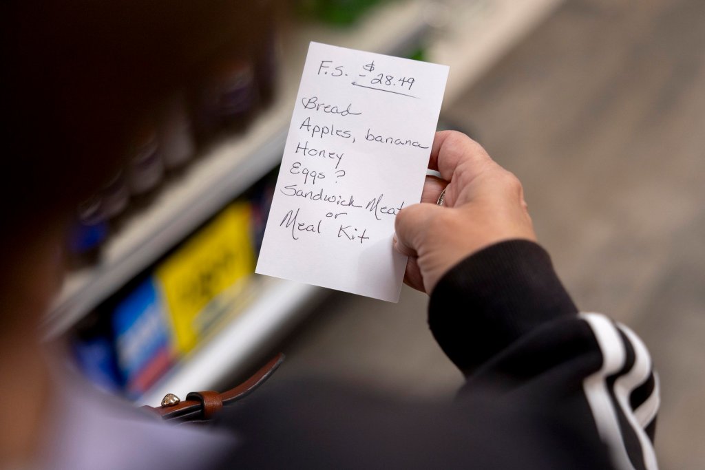 A grocery list, including "bread, apples, banana, honey, eggs?, sandwich meat or meal kit."